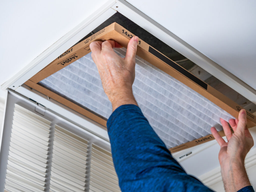 HVAC technician replacing a home air filter in Baldwin Park