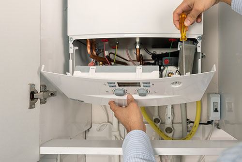 Heating technician repairing a residential boiler in Baldwin Park