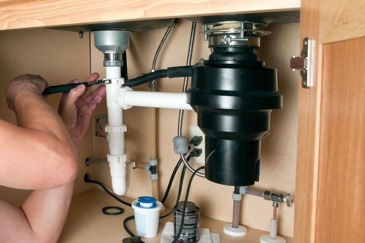 Plumber repairing a garbage disposal in Baldwin Park